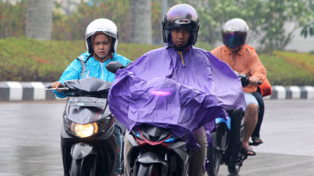Pengendara sepeda motor melintasi Jalan Rahadi Oesman yang basah setelah hujan turun, di Pontianak. Foto: ANTARA FOTO/Jessica Helena Wuysang