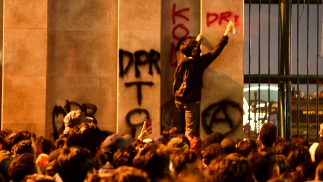 Coretan logo Anarko di gerbang DPR RI saat berunjuk rasa menolak UU yang menuai polemik, pada Senin (23/9/2019). Foto: ANTARA FOTO/Aditya Pradana Putra