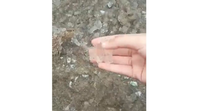 Warga memegang butiran-butiran es yang turun bersamaan dengan hujan di Desa Pulau Muda, Teluk Meranti, Pelalawan, Riau, Senin sore (23/9).