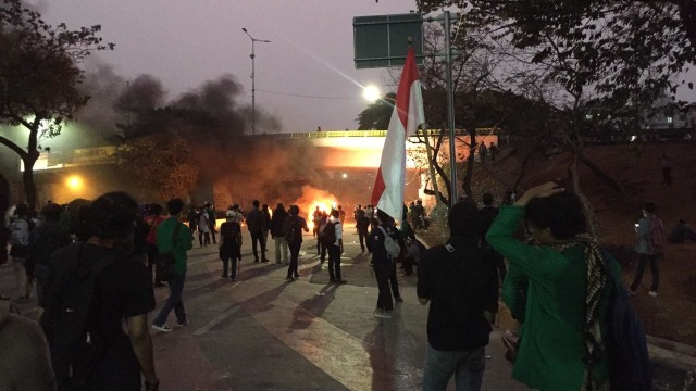 Sejumlah massa membakar ban di Jalan Tol dalam kota saat menggelar unjuk rasa di kawasan DPR RI, Jakarta, Selasa (24/9/2019). Foto: Raga Imam/kumparan