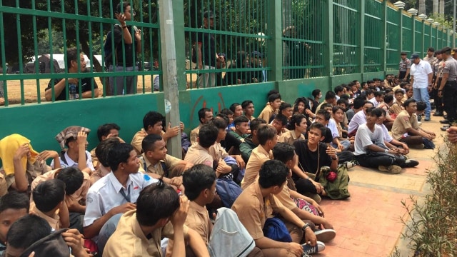 Para pelajar yang berdemo dikumpulkan polisi di depan trotoar gedung DPR RI, Jakarta. Foto: Muhammad Darisman/kumparan