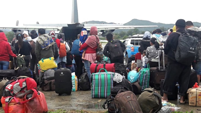 Warga antre menaiki pesawat milik TNI di Bandara Wamena, Jayawijaya, Papua, Sabtu (28/9/2019). Foto: ANTARA FOTO/Iwan Adisaputra