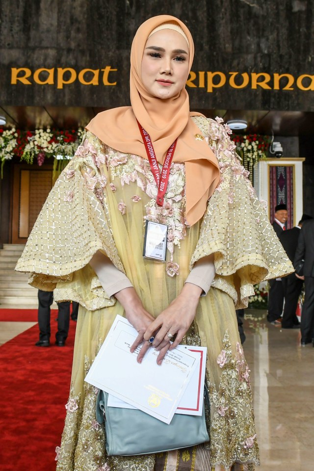 Penyanyi Mulan Jameela barpose sebelum mengikuti pelantikan Dewan Perwakilan Rakyat (DPR) periode 2019-2024 di Ruang Rapat Paripurna, Kompleks Parlemen, Senayan, Jakarta. Foto: ANTARA FOTO/Galih Pradipta
