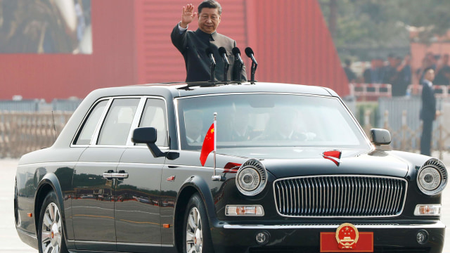 Presiden Tiongkok Xi Jinping melambai dari sebuah kendaraan saat dia meninjau pasukan di parade militer di Beijing. Foto: REUTERS/Thomas Peter