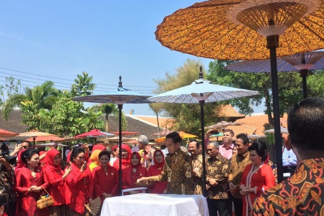 Presiden Joko Widodo (tengah) membatik di Komplek Istana Mangkunagaran, Surakarta, Jawa Tengah. Foto: Ema Fitriyani/kumparan