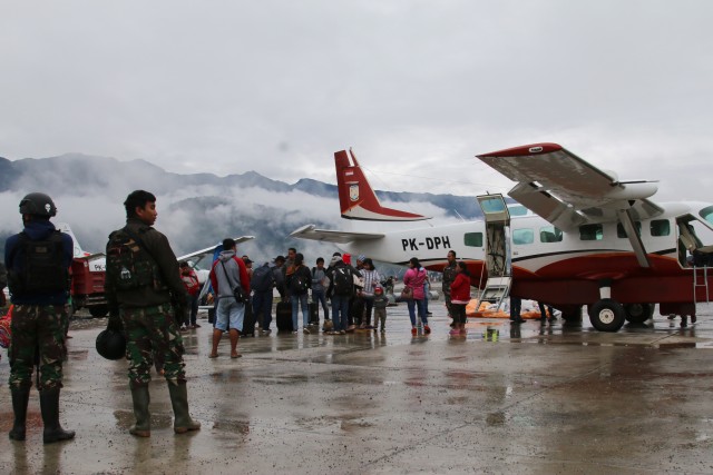 Warga menunggu pesawat dengan penjagaan aparat keamanan di Bandara Ilaga, Kabupaten Puncak, Papua, Selasa (1/10/2019). Foto: ANTARA FOTO/Sevianto Pakiding