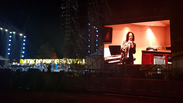 Kenny G (di layar) saat memainkan saxophone sambil berduet dengan David Foster di panggung Batik Music Festival 2019 di Candi Prambanan, Sabtu (5/10/2019). Foto: adn.
