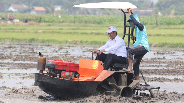 Menteri Pertanian Andi Amran Sulaiman (kiri) mengendarai traktor rawa saat kunjungan kerja di Desa Jabon, Kediri, Jawa Timur, Rabu (9/10/2019). Foto: ANTARA FOTO/Prasetia Fauzani