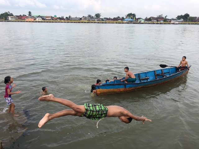 Seorang anak meloncat ke Sungai Kapuas di Pontianak saat airnya jernih, Kamis sore (10/10). Foto: Teri/Hi!Pontianak