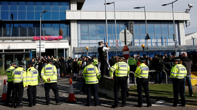 Seorang pengunjuk rasa Pemberontakan Kepunahan berdiri di atas atap Bandara London City, di London. Foto: REUTERS / Henry Nicholls