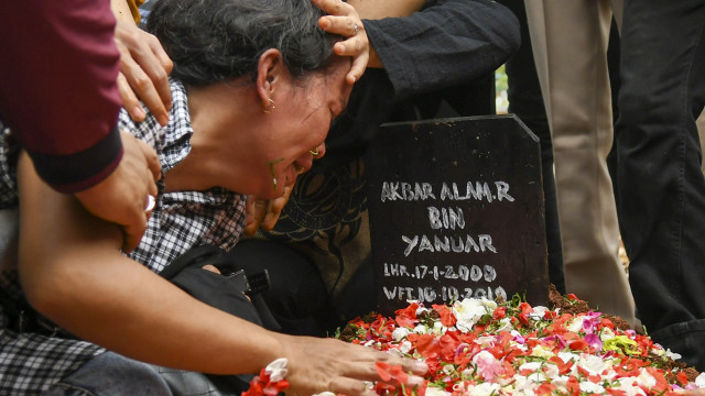 Ibu Akbar Alamsyah, Rosminah (kiri) menangis saat prosesi pemakaman korban demo ricuh Akbar Alamsyah di TPU kawasan Cipulir, Kebayoran Lama, Jakarta, Jumat (11/10/2019). Foto: ANTARA FOTO/Galih Pradipta
