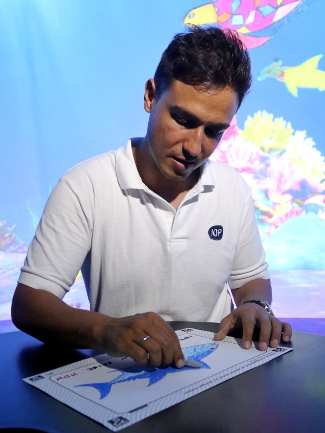 Hamish Daud mewarnai gambar ikan di teamlab Future Park, Jumat (11/10/2019). Foto: Helinsa Rasputri/kumparan