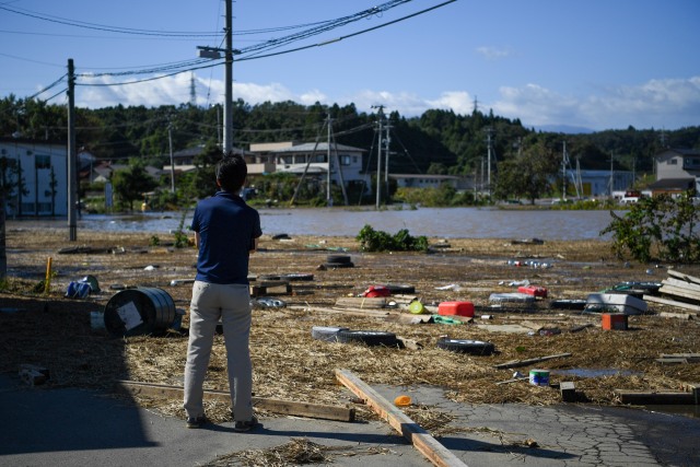 Seorang warga melihat kepuing puing setelah topan hagibis melanda Distrik Shibata, Prefektur Miyagi, Jepang. Minggu (13/10/2019). Foto: AFP/Charly Triballeau