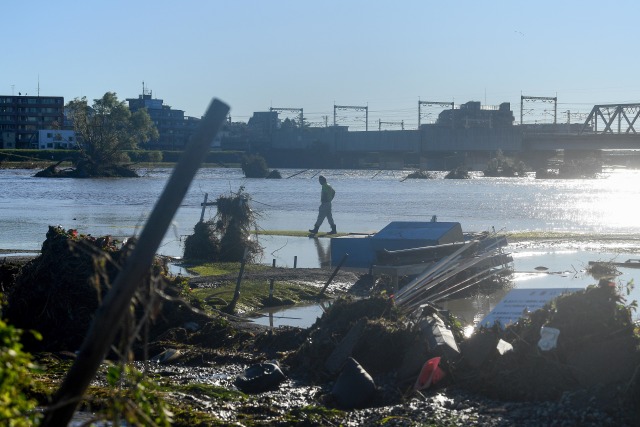 Seorang warga berjalan disekitar kawasan yang terendam banjir yang disebabkan oleh Topan Hagibis. Foto: AFP/Franck Fife