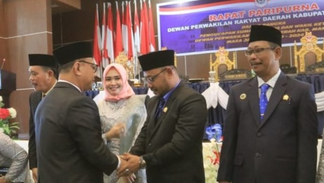Bupati Mamuju, Habsi Wahid, menyalami putranya, Azwar Anshari Habsi, yang menjabat Ketua DPRD Mamuju Periode 2019-2024. Foto: Awal Dion/SulbarKini