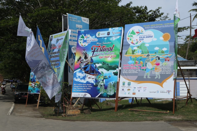 Spanduk Festival Pesona Bahari Raja Ampat 2019 dapat dijumpai di sepanjang jalan menuju lokasi peresmian di Pantai WTC, Raja Ampat, Papua. Foto: Aria Saankhyadi/kumparan