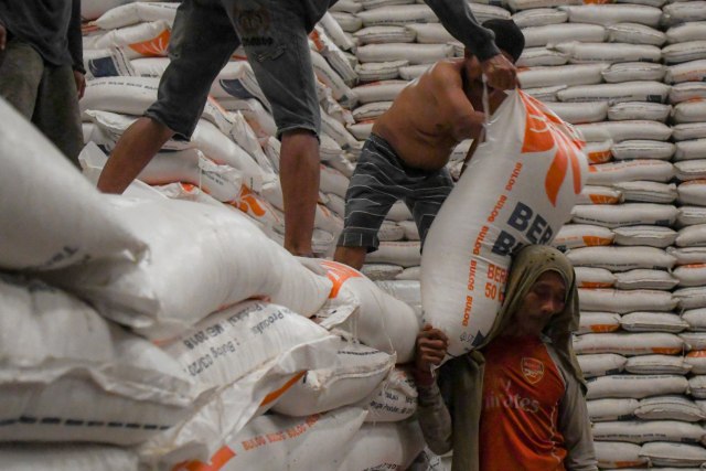 Pekerja memanggul karung beras Bulog untuk dipindahkan kedalam mobil box di Gudang Bulog Kelapa Gading, Jakarta. Foto:  ANTARA FOTO/Nova Wahyudi