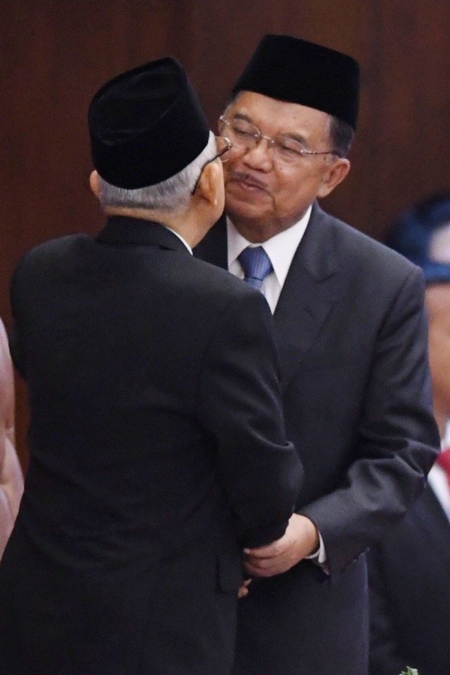 Mantan Wakil Presiden Jusuf Kalla (kanan) berpelukan dengan Wakil Presiden Ma'ruf Amin pada upacara pelantikan presiden dan wakil presiden di kompleks Parlemen. Foto: ANTARA FOTO/Akbar Nugroho Gumay