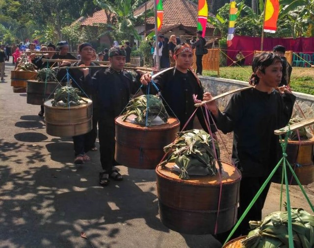 Arak-arakan sembari membawa tetenong (wadah makanan terbuat dari anyaman bambu) yang berisi beragam makanan khas Desa Cibuntu, Kecamatan Pasawahan, Kabupaten Kuningan, Jawa Barat, menjadi salah satu ritual dalam sedekah bumi di desa setempat. (Andri)