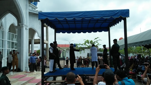 Algojo menghunus rotan saat mengeksekusi hukuman cambuk terhadap empat terpidana maisir (perjudian) yang dilaksanakan di Masjid Babuttaqwa Batoh, Banda Aceh, Senin (21/10). Foto: Husaini Ende/acehkini