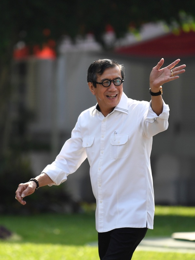 Yasonna Laoly melambaikan tangan saat tiba Kompleks Istana Kepresidenan, Jakarta.  Foto: ANTARA FOTO/Puspa Perwitasari/