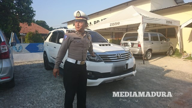 Anggota Polantas menunjukkan mobil Fortuner yang diduga milik Kades Bencelok saat diamankan di Unit Laka Satlantas Polres Sampang, Rabu (23/10/2019) sore. (Ryan/MM). 