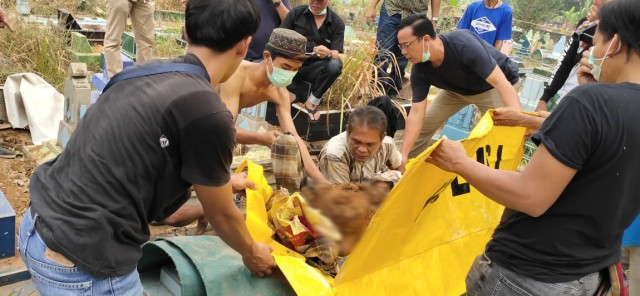 Polisi bersama keluarga korban saat membongkar jasad Apriyanita yang dicor di area TPU Kandang Kawat. (foto: istimewa)