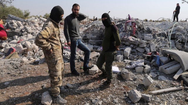 Sejumlah orang menghampiri lokasi yang diduga serangan AS terhadap Pemimpin ISIS, Abu Bakr al-Baghdadi di desa Barisha, Suriah. Foto: AP Photo/Ghaith Alsayed