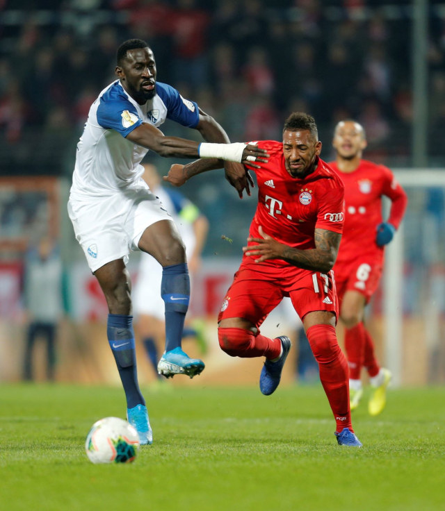 Jerome Boateng berduel dengan Silvere Ganvoula. Foto: REUTERS/Leon Kuegeler