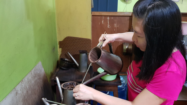 Seorang pegawai warkopies sedang menyedu kopi pesanan konsumen. (Jr)