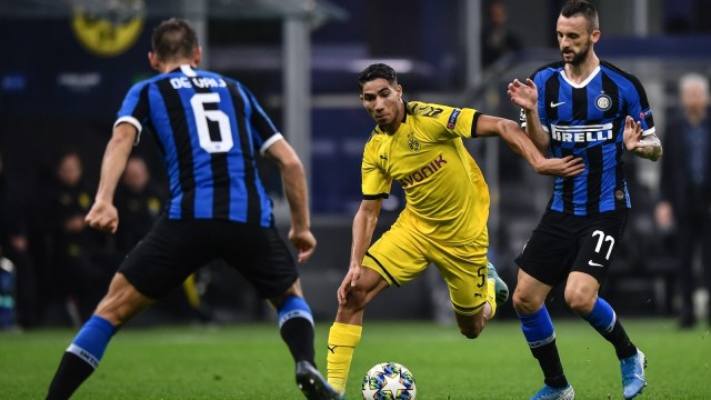 Pemain Dortmund, Achraf Hakimi, dikepung Stefan de Vrij dan Marcelo Brozovic. Foto: AFP/Marco Bertorello