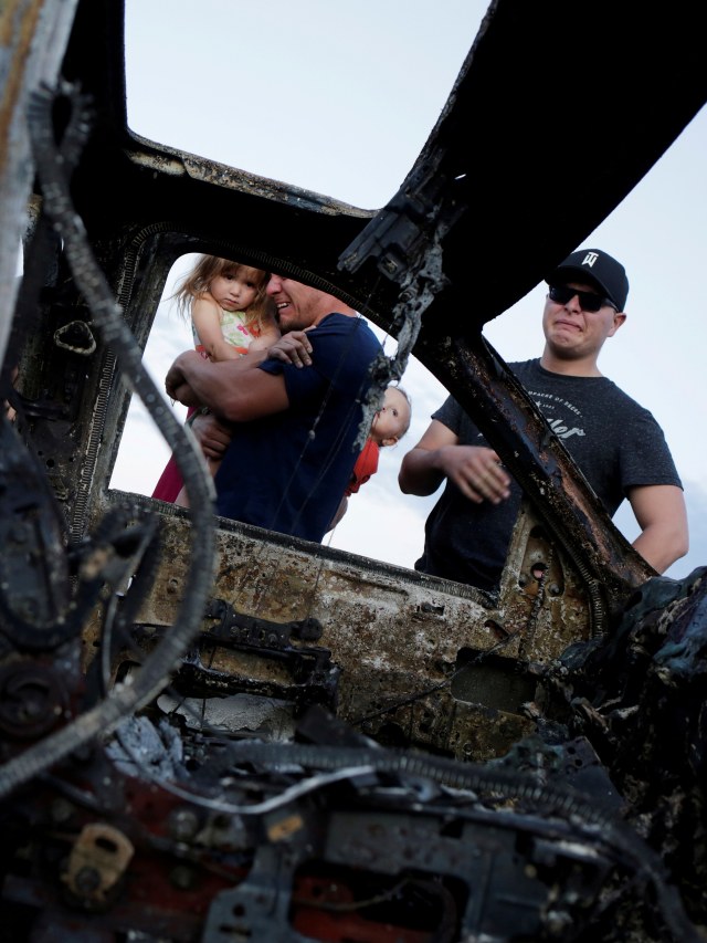 Keluarga melihat mobil milik salah satu keluarga Mormon Meksiko-Amerika yang terbakar karena diserang oleh orang tidak dikenal, di Bavispe, Sonora, Meksiko, Selasa (5/112019). Foto: REUTERS/Jose Luis Gonzalez