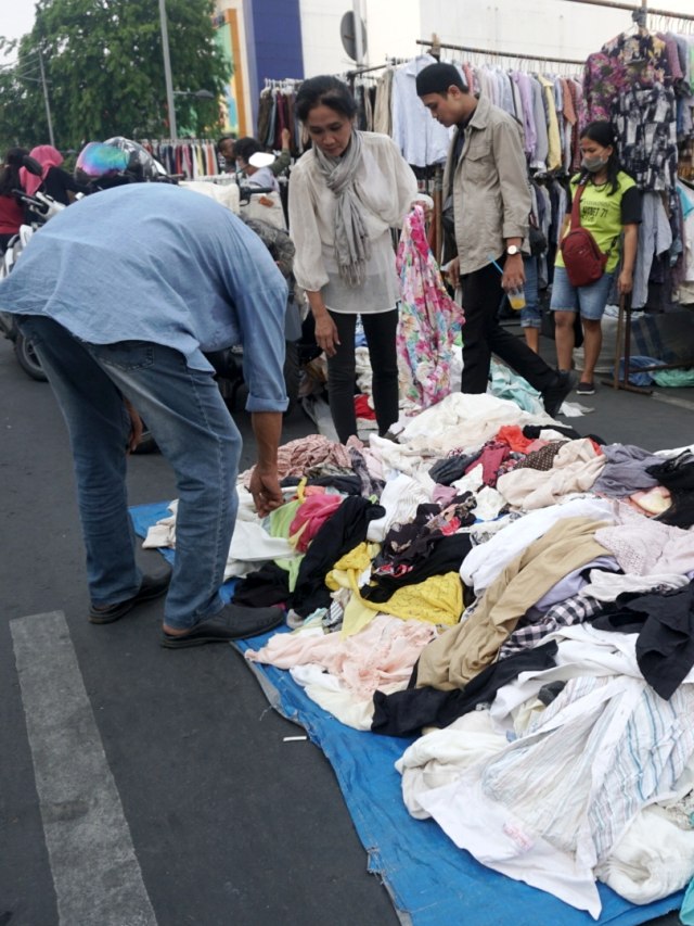 Pembeli melihat-lihat pakaian di lapak pakaian bekas di kawasan Jalan Pasar Senen, Jakarta.
Foto: Iqbal Firdaus/kumparan