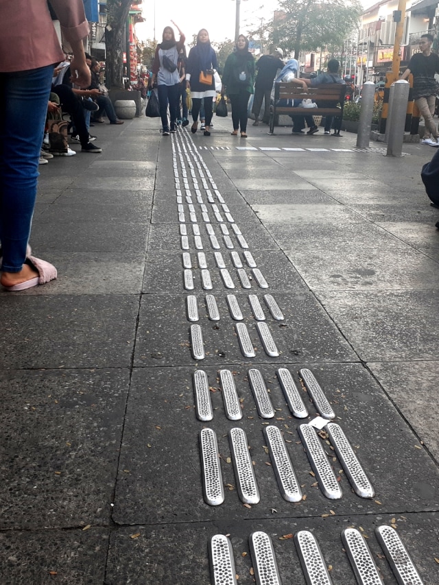 Guiding block atau penunjuk jalan untuk tunanetra di kawasan pendestrian Malioboro, Yogyakarta, terlepas.
 Foto: Arfiansyah Panji Purnandaru/kumparan
