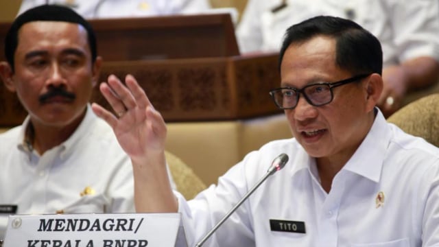 Mendagri Tito Karnavian (kanan) menyampaikan paparannya saat mengikuti rapat kerja dengan Komisi II DPR di Kompleks Parlemen, Senayan, Jakarta, Rabu (6/11).  Foto: Dok. Kemendagri 