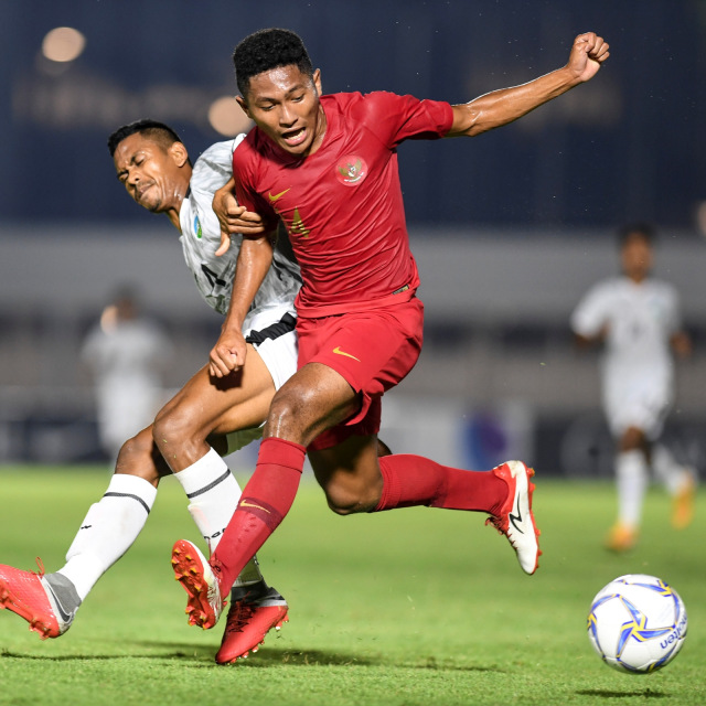 Pemain timnas Indonesia U-19 Muhammad Fajar Fathur (kanan) berusaha melewati pemain timnas Timor Leste U-19 pada laga Pra Piala Asia, Rabu (6/11). Foto: ANTARA FOTO/Hafidz Mubarak A