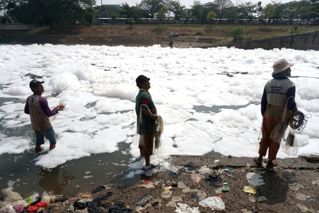 Warga mencari ikan di area limbah busa yang muncul di Pintu Air KBT di Ujung Menteng, Jakarta Timur, Kamis (7/11). Foto: Iqbal Firdaus/kumparan