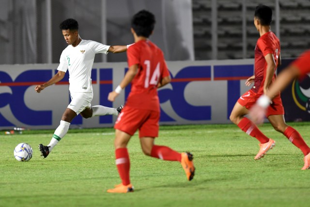 Pemain Timnas Indonesia U-19 Amiruddin Bagas Arrizqi (kiri) menendang bola ke arah gawang Timnas Hong Kong U-19 di Stadion Madya GBK, Jakarta, Jumat (8/11). Foto: ANTARA FOTO/Aditya Pradana Putra