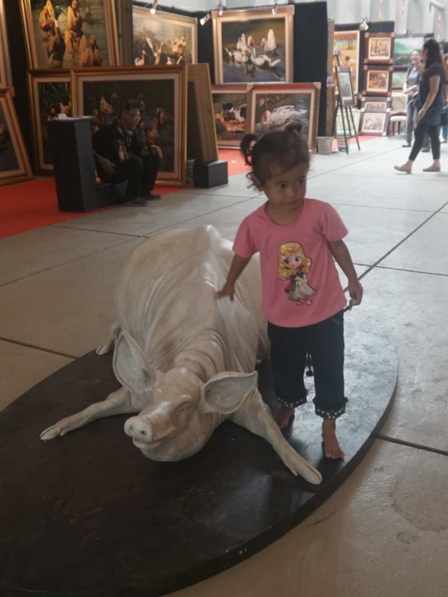 Seorang anak berfoto dengan patung di acara Pameran Indonesian Art Festival 2019 di Taman Sanken, Museum Nasional Indonesia, Jakarta Pusat.
Foto: Iqbal Firdaus/kumparan