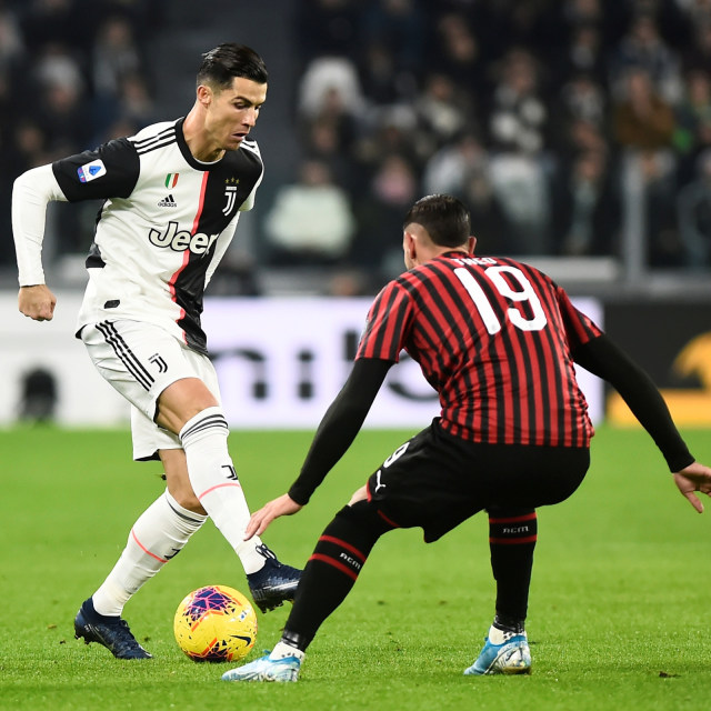 Pemain Juventus, Cristiano Ronaldo, diadang oleh pemain AC Milan, Theo Hernandez. Foto: REUTERS/Massimo Pinca