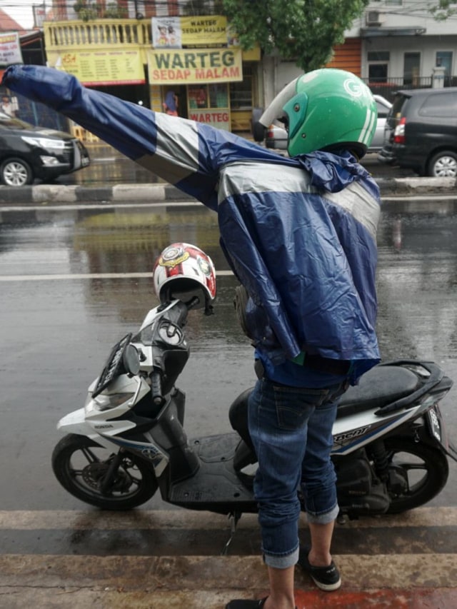 Seorang pengendara sepeda motor memakai jas hujan ketika melintas di Jalan Dewi Sartika, Jakarta Timur (13/11).  Foto: Iqbal Firdaus/kumparan