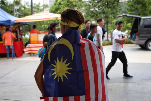 Pendukung Timnas Malaysia membawa bendera bendera Malaysia jelang pertandingan Timnas Indonesia melawan Timnas Malaysia di Stadion Bukit Jalil, Malaysia.  Foto: Jamal Ramadhan/kumparan 