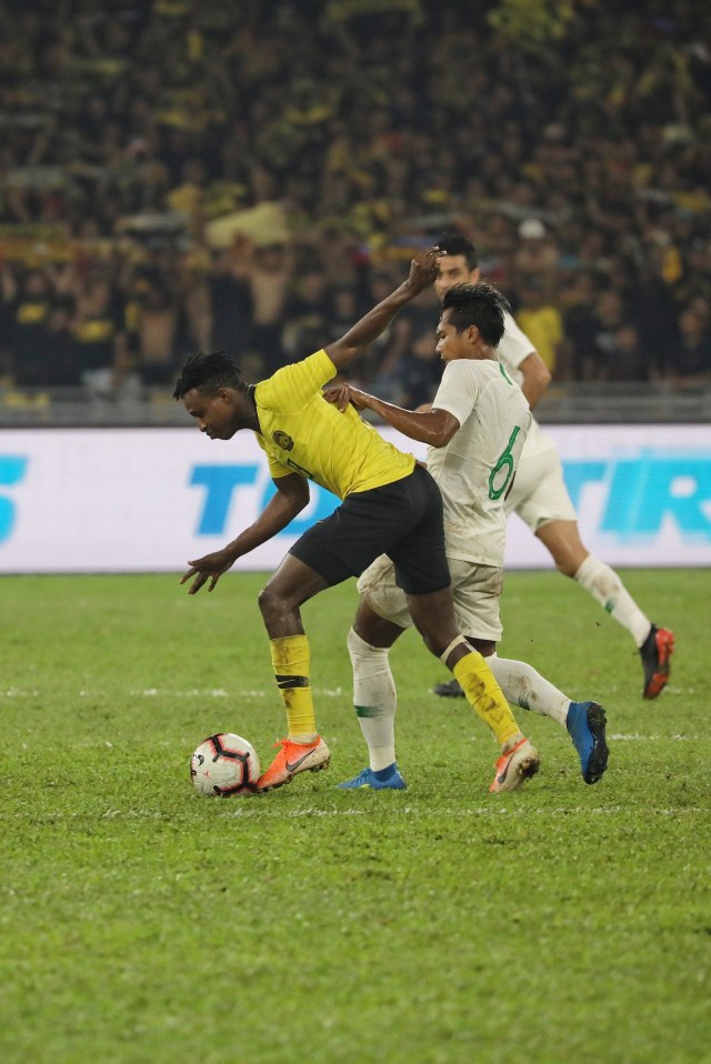 Pemain Timnas Indonesia, Hendro Siswanto (kanan), berebut bola dengan pemain Timnas Malaysia di Stadion Bukit Jalil, Malaysia. Foto: Jamal Ramadhan/kumparan 
