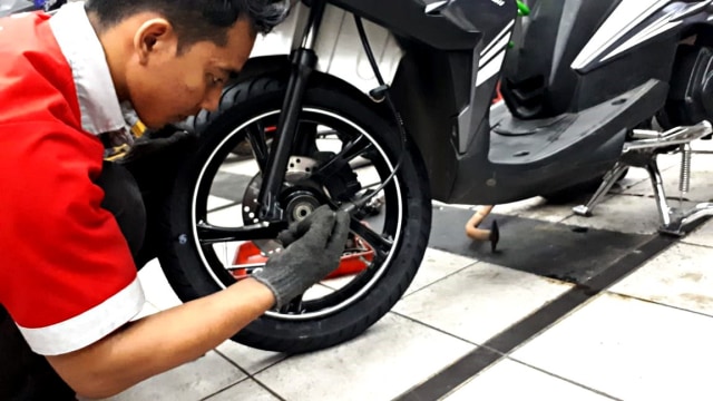 Ilustrasi memasang ban motor. Foto: Aditia Noviansyah/kumparan
