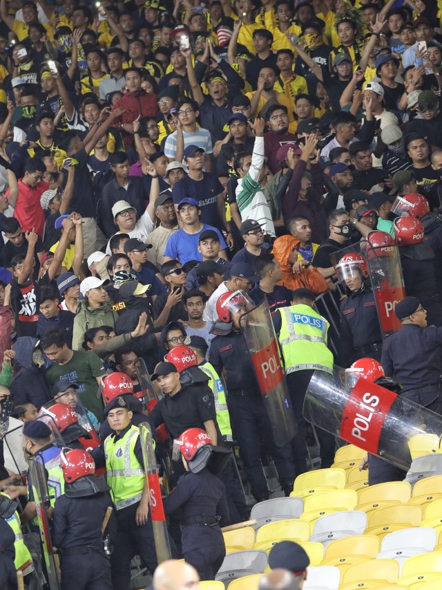 Polisi Malaysia berjaga didekat suporter Malaysia saat pertandingan Timnas Indonesia melawan Malaysia di Stadion Bukit Jalil, Malaysia. Foto: Jamal Ramadhan/kumparan