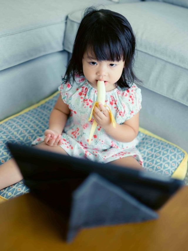 Ilustrasi balita makan sambil nonton lewat gadget. Foto: Shuter Stock