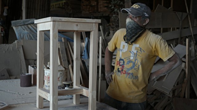 Seorang pekerja sedang mengamati meja hasil produksi di Industri Mebel Jatinegara Kaum, Jakarta TImur, Rabu (27/11). Foto: Iqbal Firdaus/kumparan
