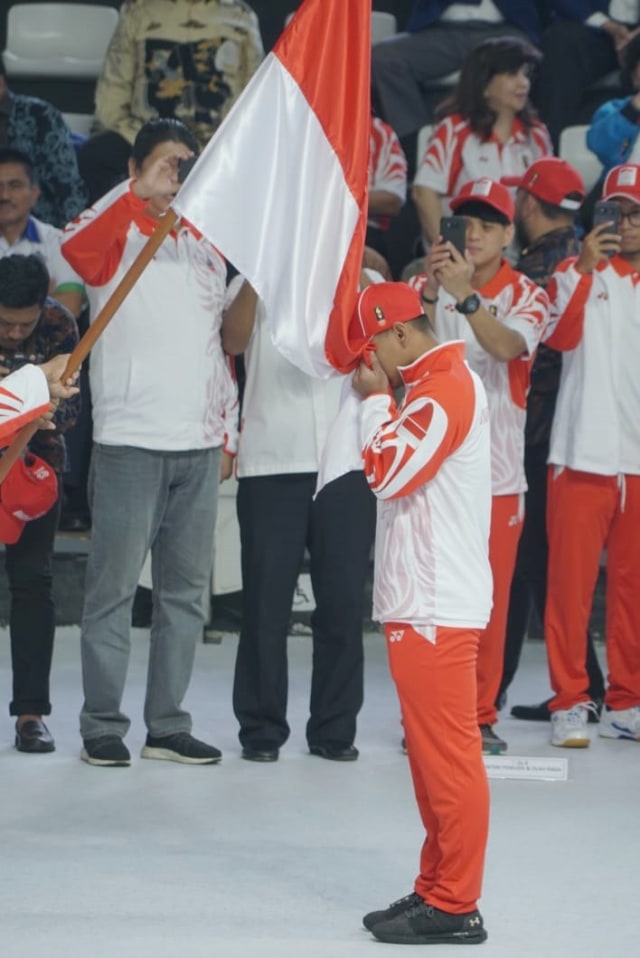 Atlet Indonesia mencium bendera merah putih saat pengukuhan kontingen Indonesia untuk SEA Games 2019 di Hall Basket GBK, Rabu (27/11/2019). Foto: Helmi Afandi Abdullah/kumparan 
