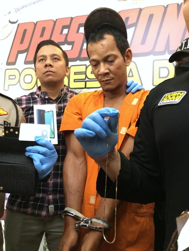 Polisi menunjukan tersangka perampok turis Jepang yang terjun dari apartemen di Bali. Foto: Denita br Matondang/kumparan