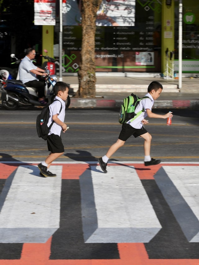 Sejumlah siswa berjalan melewati persimpangan pejalan kaki 3D di Bangkok, Thailand.  Foto:  REUTERS / Chalinee Thirasupa